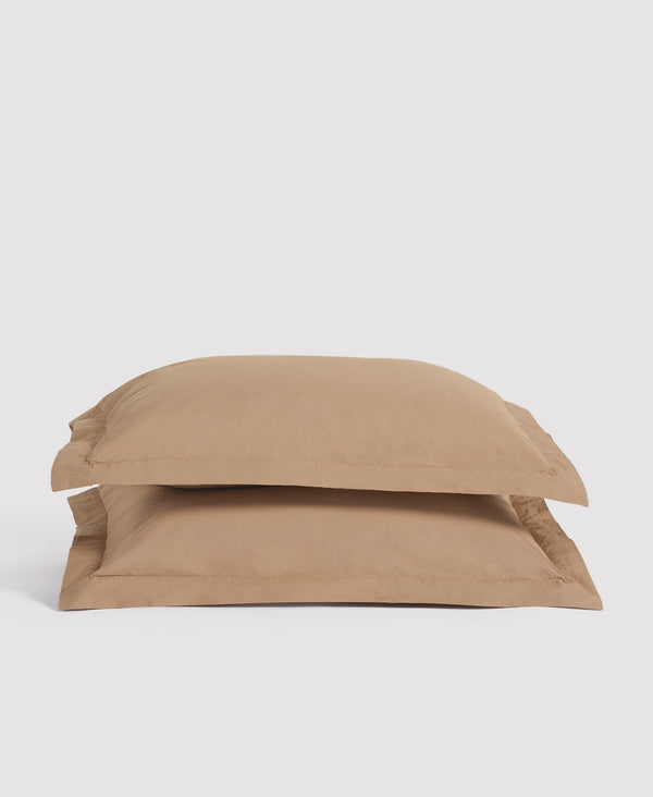 Two beige linen pillowcases stacked on white background, showing natural texture and envelope closure design