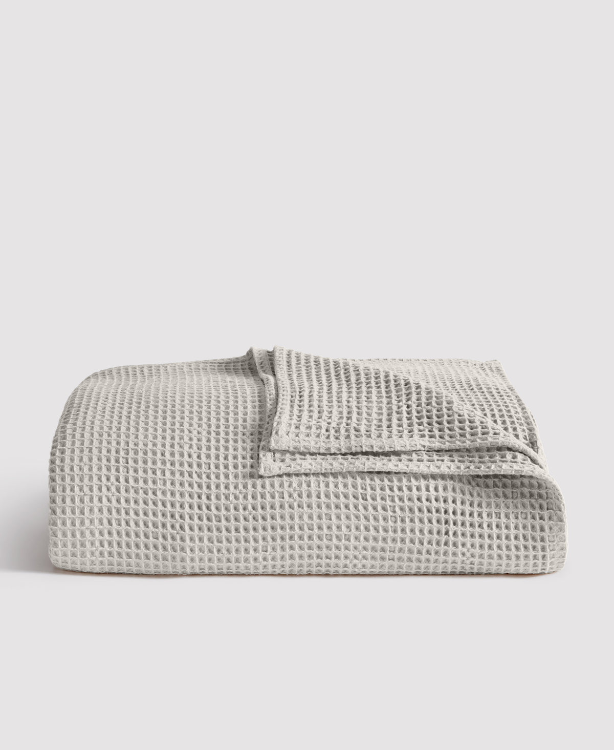Gray waffle weave blanket folded neatly against white background