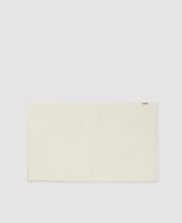 Light green woven placemat with fringed edges on white background