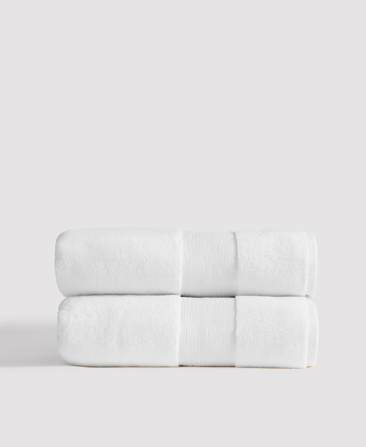 Two neatly stacked white towels with gray decorative bands against a light gray background