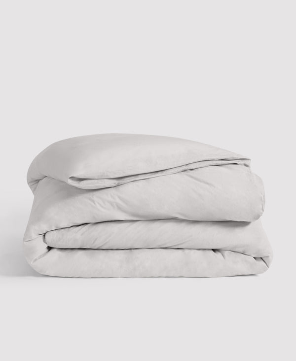 Neatly folded light gray duvet cover stacked against white background